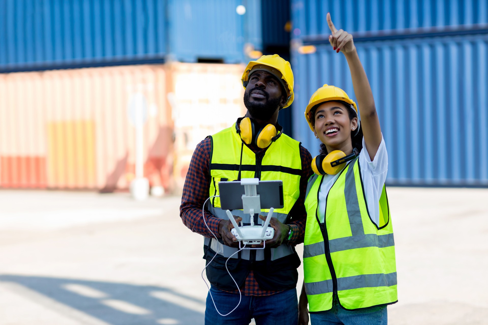 Foreman or worker use remote controller piloting drone at containers port for checking container. Foreman use remote control Drone with camera flying on container cargo ship at shipping port.